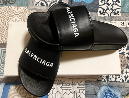 Black Balenciaga slides with white logo