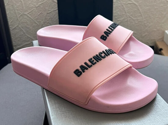 pink balenciaga pool slides with black logo