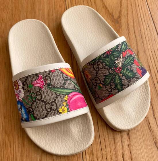 Fashionable Gucci slides designed with a bold floral print and double-G logo.